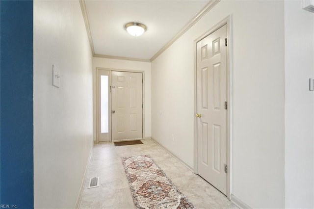 entryway with ornamental molding, visible vents, and baseboards