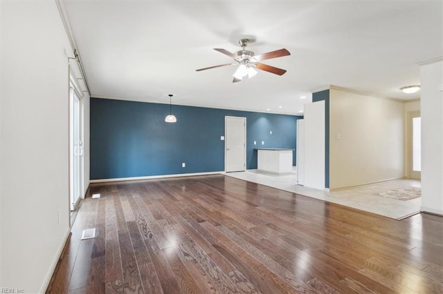 unfurnished living room featuring ceiling fan, crown molding, baseboards, and hardwood / wood-style floors