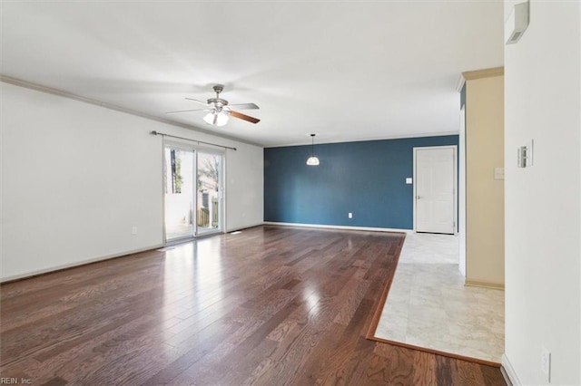 unfurnished room featuring ceiling fan, ornamental molding, wood finished floors, and baseboards