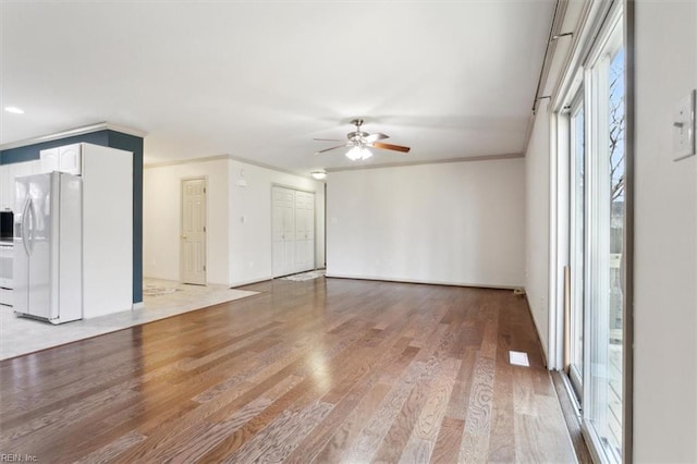 unfurnished room with light wood-style floors, ceiling fan, and ornamental molding