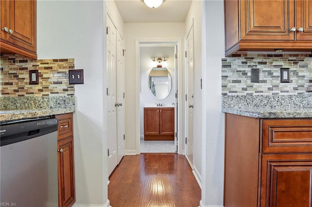 hallway featuring baseboards, dark wood finished floors, and a sink