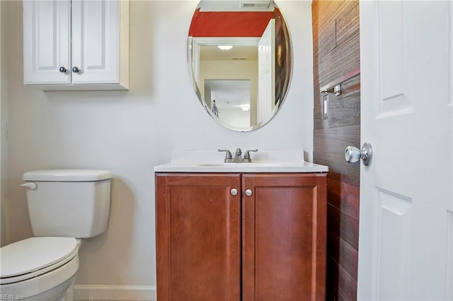 bathroom featuring toilet, visible vents, vanity, and baseboards