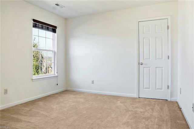 unfurnished room with light carpet, baseboards, and visible vents