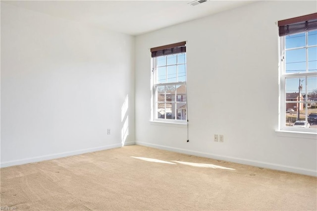 spare room with light carpet and baseboards