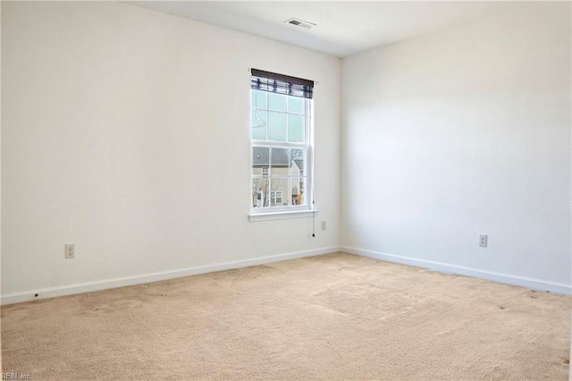 spare room with carpet, visible vents, and baseboards