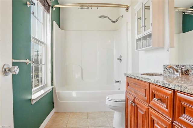 bathroom featuring toilet, vanity, baseboards, tub / shower combination, and tile patterned floors