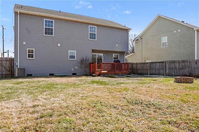 rear view of property featuring a deck, fence private yard, a fire pit, a yard, and crawl space