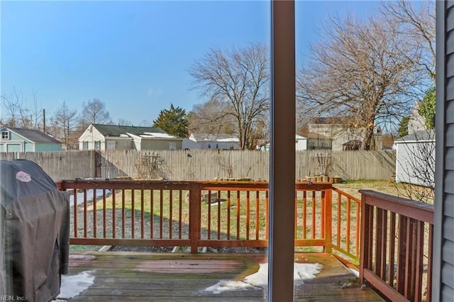 wooden terrace with a fenced backyard, a residential view, and a grill