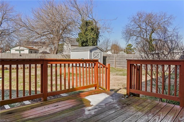 deck with a storage shed, an outdoor structure, and a fenced backyard