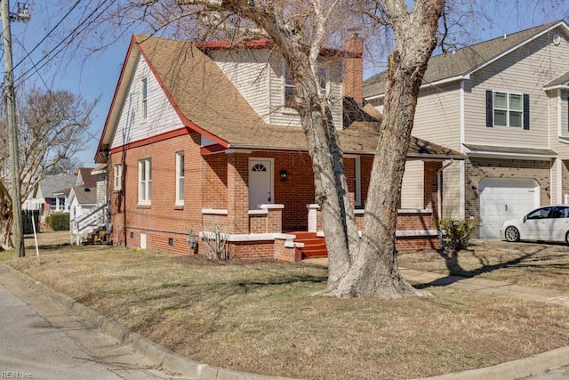 view of front of house featuring brick siding, roof with shingles, an attached garage, crawl space, and a front lawn