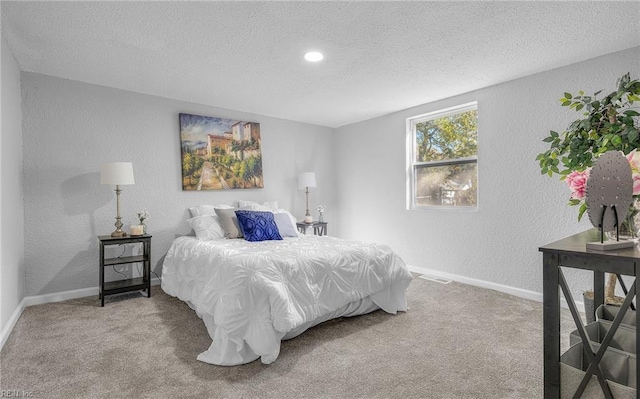 bedroom featuring a textured ceiling, a textured wall, carpet, and baseboards