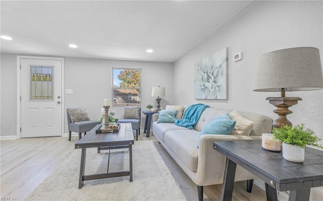 living area featuring baseboards, wood finished floors, and recessed lighting