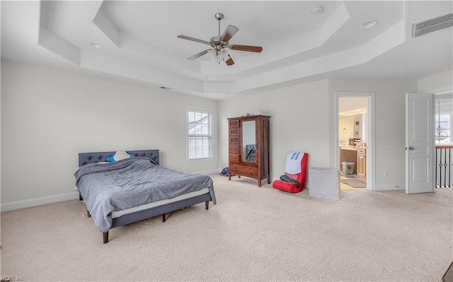 bedroom with light colored carpet, a raised ceiling, and visible vents