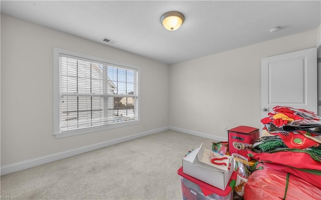 recreation room with carpet, visible vents, and baseboards