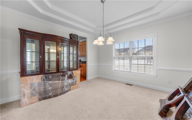 dining space with light colored carpet, a notable chandelier, visible vents, baseboards, and a raised ceiling