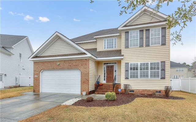 traditional-style home featuring brick siding, an attached garage, fence, driveway, and a front lawn