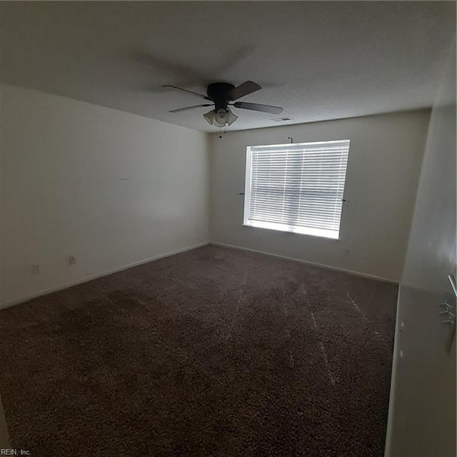 carpeted spare room with ceiling fan and baseboards