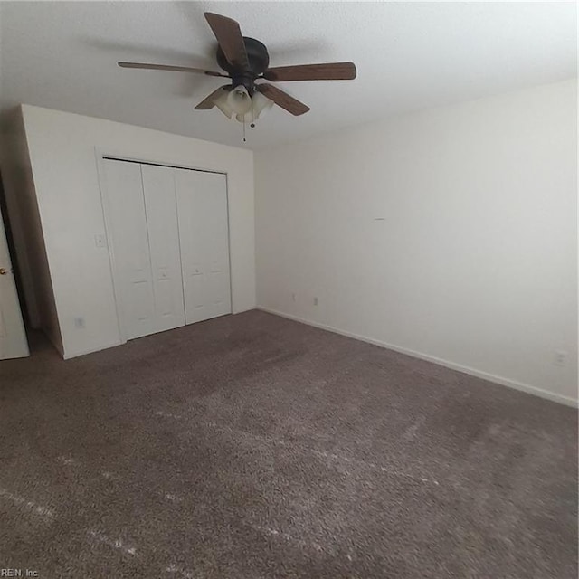 unfurnished bedroom with ceiling fan, a closet, and dark carpet