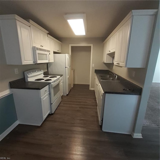 kitchen featuring dark countertops, white appliances, white cabinetry, and dark wood finished floors