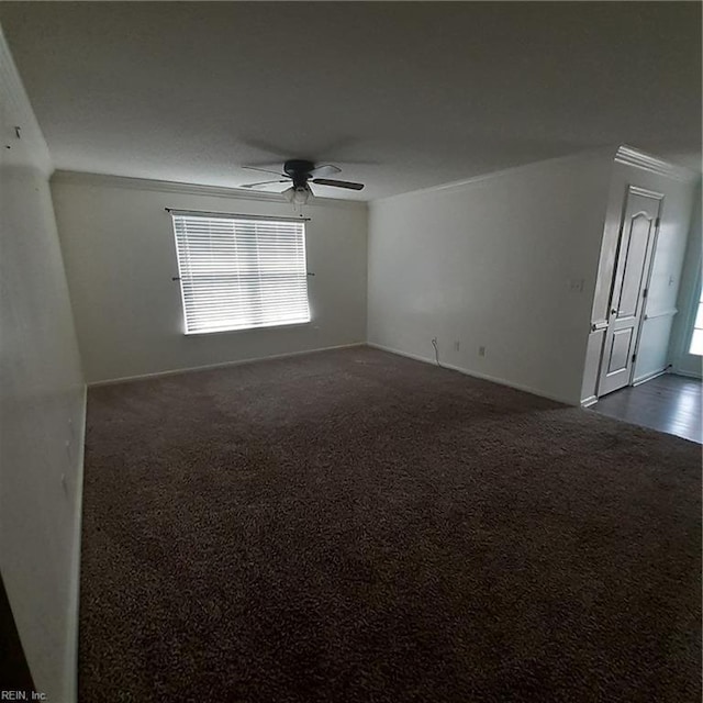 spare room with a ceiling fan and dark carpet