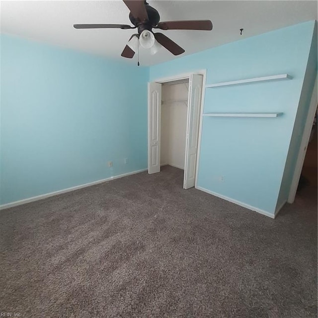 unfurnished bedroom featuring a closet, baseboards, dark colored carpet, and a ceiling fan