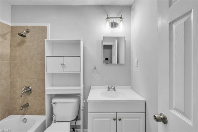 bathroom featuring tub / shower combination, vanity, and toilet