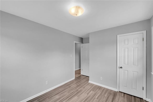 unfurnished bedroom featuring baseboards and wood finished floors