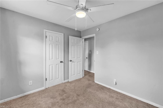 unfurnished bedroom featuring a ceiling fan, a closet, carpet flooring, and baseboards