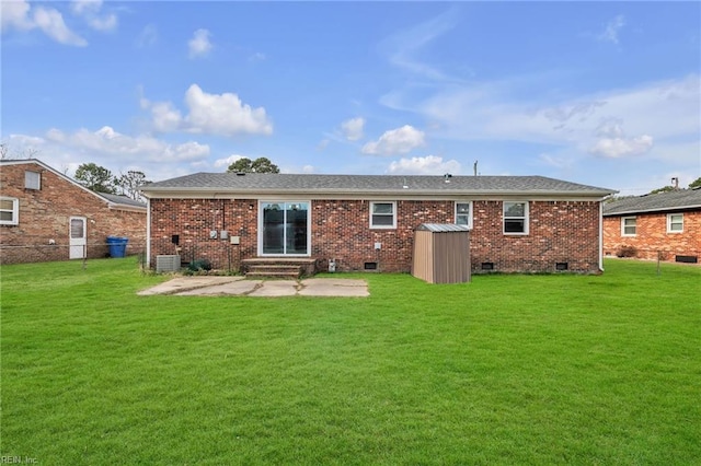 rear view of house featuring a patio, brick siding, and a lawn