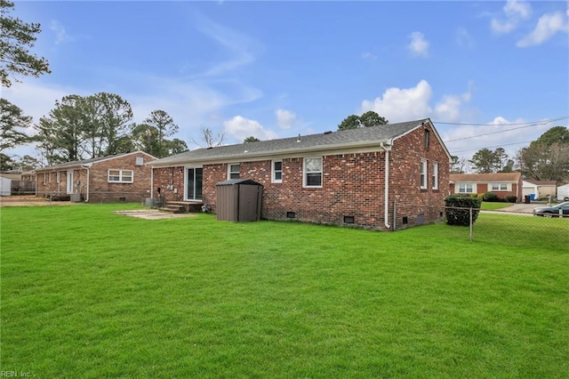 rear view of house with a yard, brick siding, and crawl space