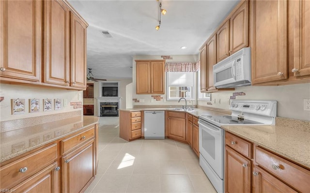 kitchen with light tile patterned floors, a ceiling fan, a glass covered fireplace, a sink, and white appliances