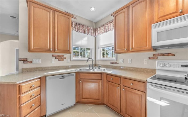 kitchen with light tile patterned flooring, recessed lighting, white appliances, a sink, and visible vents