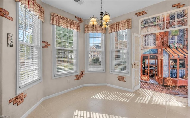 unfurnished dining area featuring visible vents, a notable chandelier, baseboards, and tile patterned floors