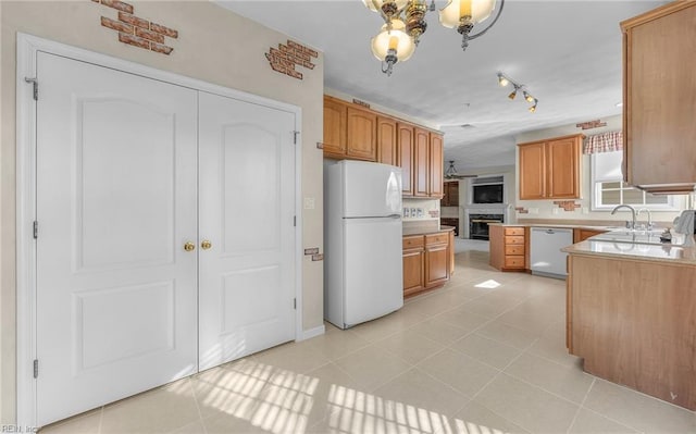 kitchen with light countertops, white appliances, light tile patterned flooring, and track lighting