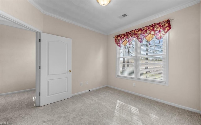 carpeted empty room with baseboards, visible vents, and crown molding