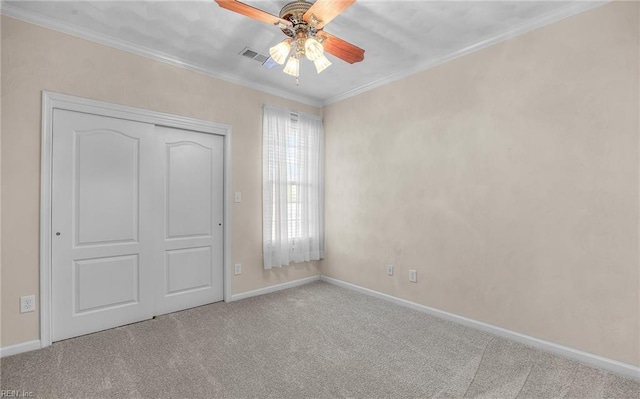 unfurnished bedroom with carpet flooring, visible vents, baseboards, ornamental molding, and a closet