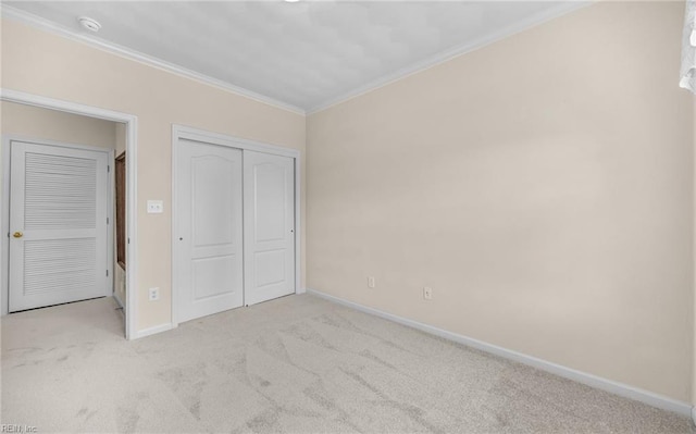 unfurnished bedroom featuring carpet, a closet, baseboards, and crown molding