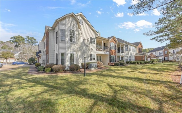 back of house with a yard, central AC, and a residential view