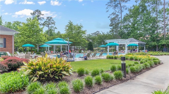 view of home's community with a patio area, a swimming pool, and a yard