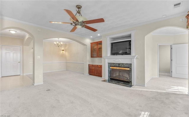 unfurnished living room with light carpet, visible vents, arched walkways, and a high end fireplace