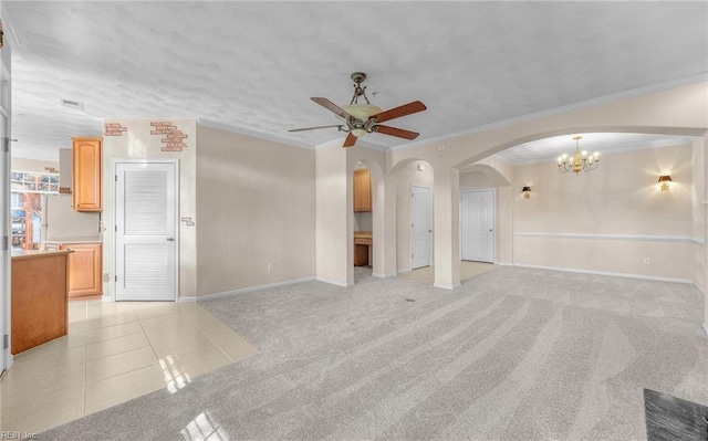 unfurnished living room with a ceiling fan, arched walkways, light colored carpet, and light tile patterned flooring