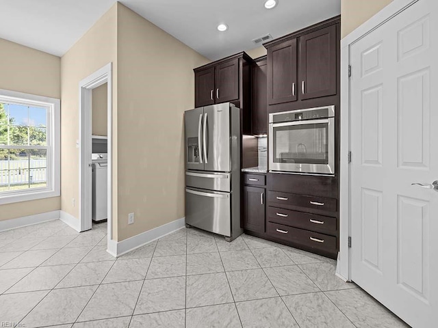 kitchen featuring visible vents, dark brown cabinets, appliances with stainless steel finishes, light countertops, and washer / clothes dryer