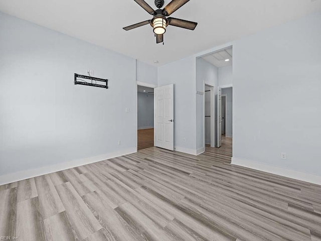 empty room featuring ceiling fan, light wood-style flooring, and baseboards