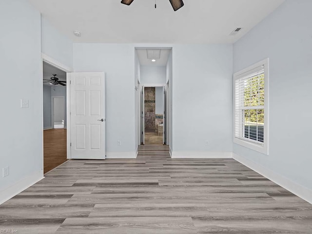 unfurnished bedroom featuring a ceiling fan, light wood-type flooring, visible vents, and baseboards