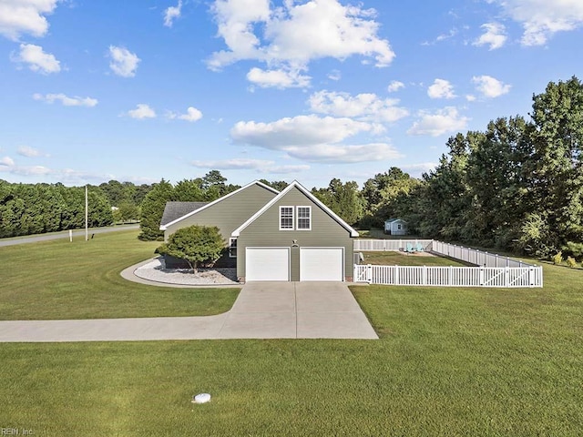 view of front of home with driveway, an attached garage, fence private yard, and a front yard