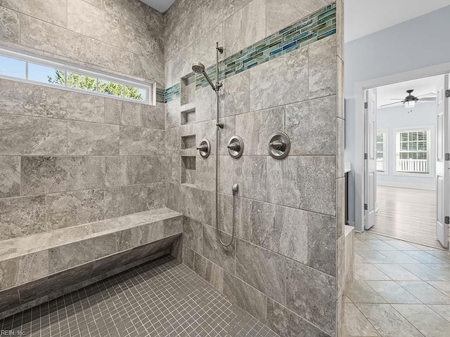 bathroom with tile patterned flooring and a tile shower