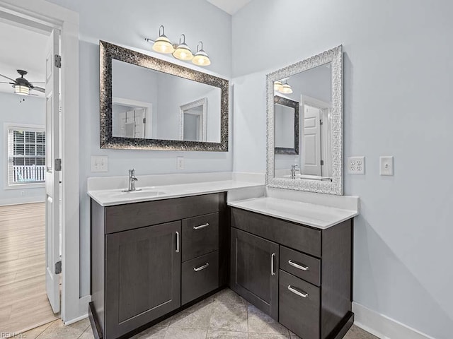 bathroom with two vanities, a sink, baseboards, and ceiling fan