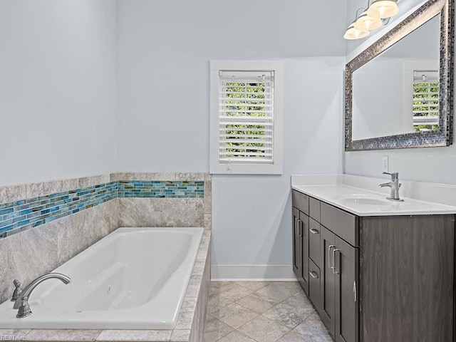 bathroom featuring a jetted tub, vanity, and baseboards