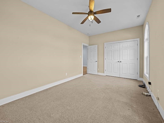 unfurnished bedroom featuring multiple windows, a closet, carpet flooring, and baseboards