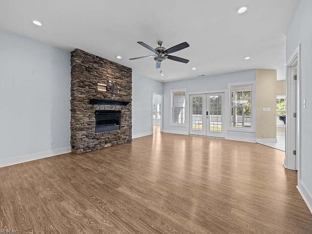 unfurnished living room featuring light wood-type flooring, french doors, a fireplace, and recessed lighting